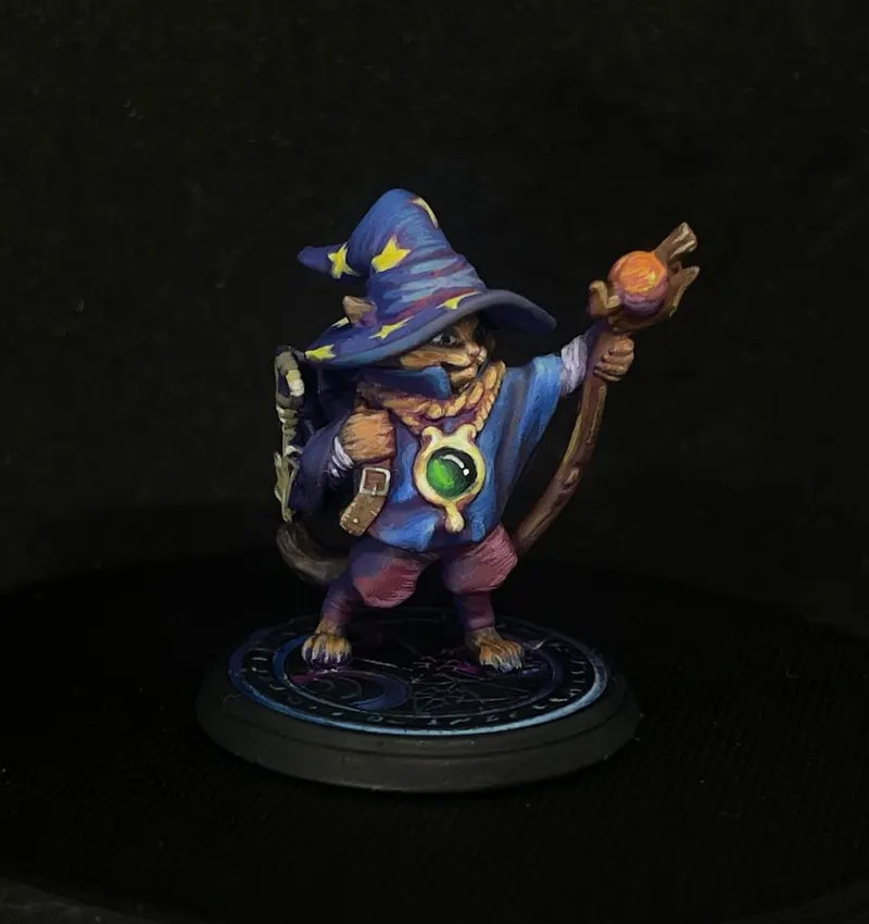 A small wizard in a blue star-covered hat holding a staff